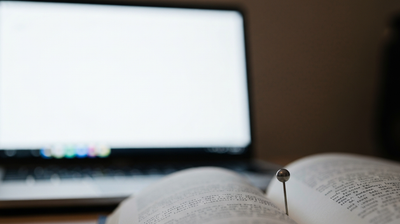 Desk with laptop, style guide, and enamel certification pin